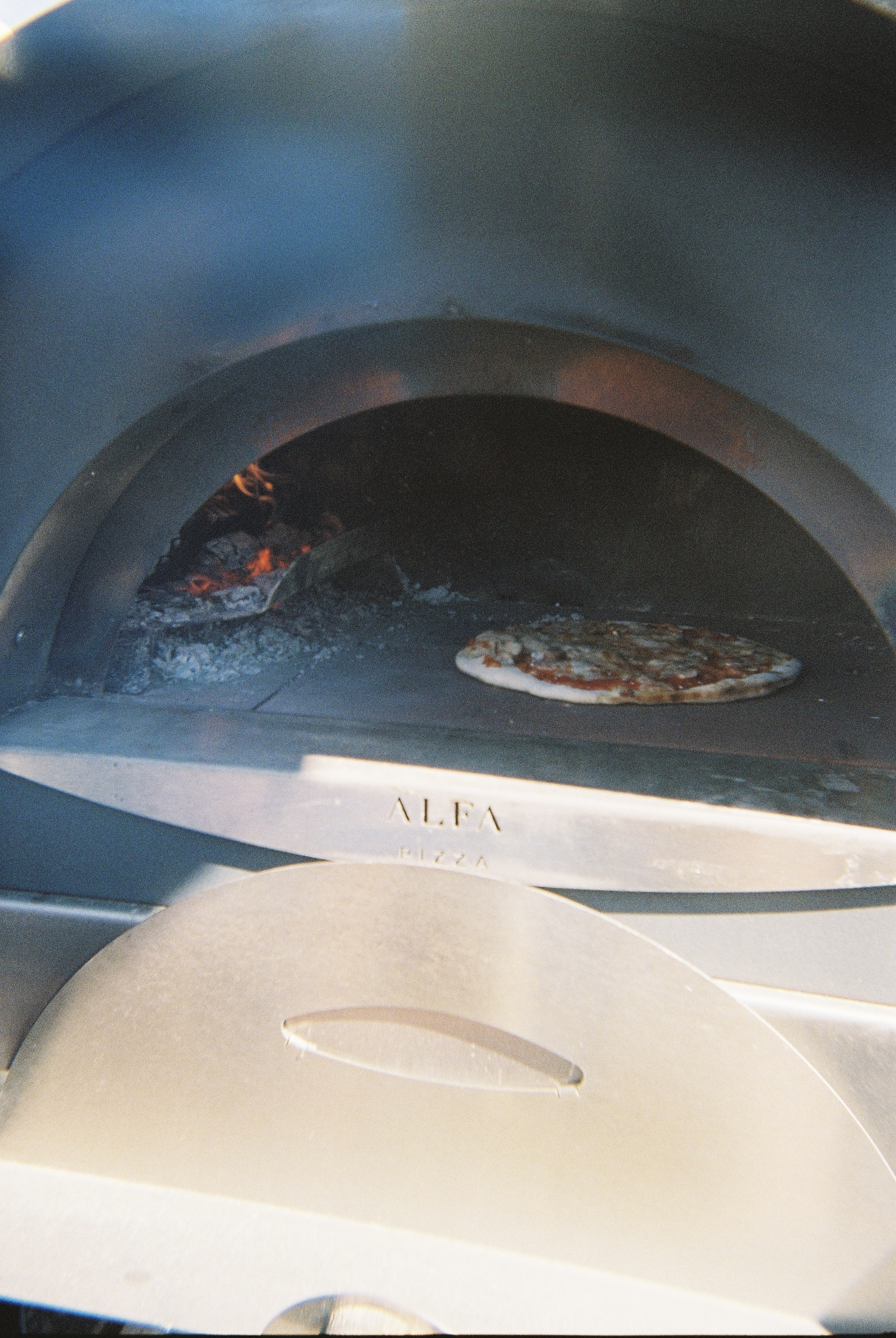 Pizza beim Backen im Holzofen