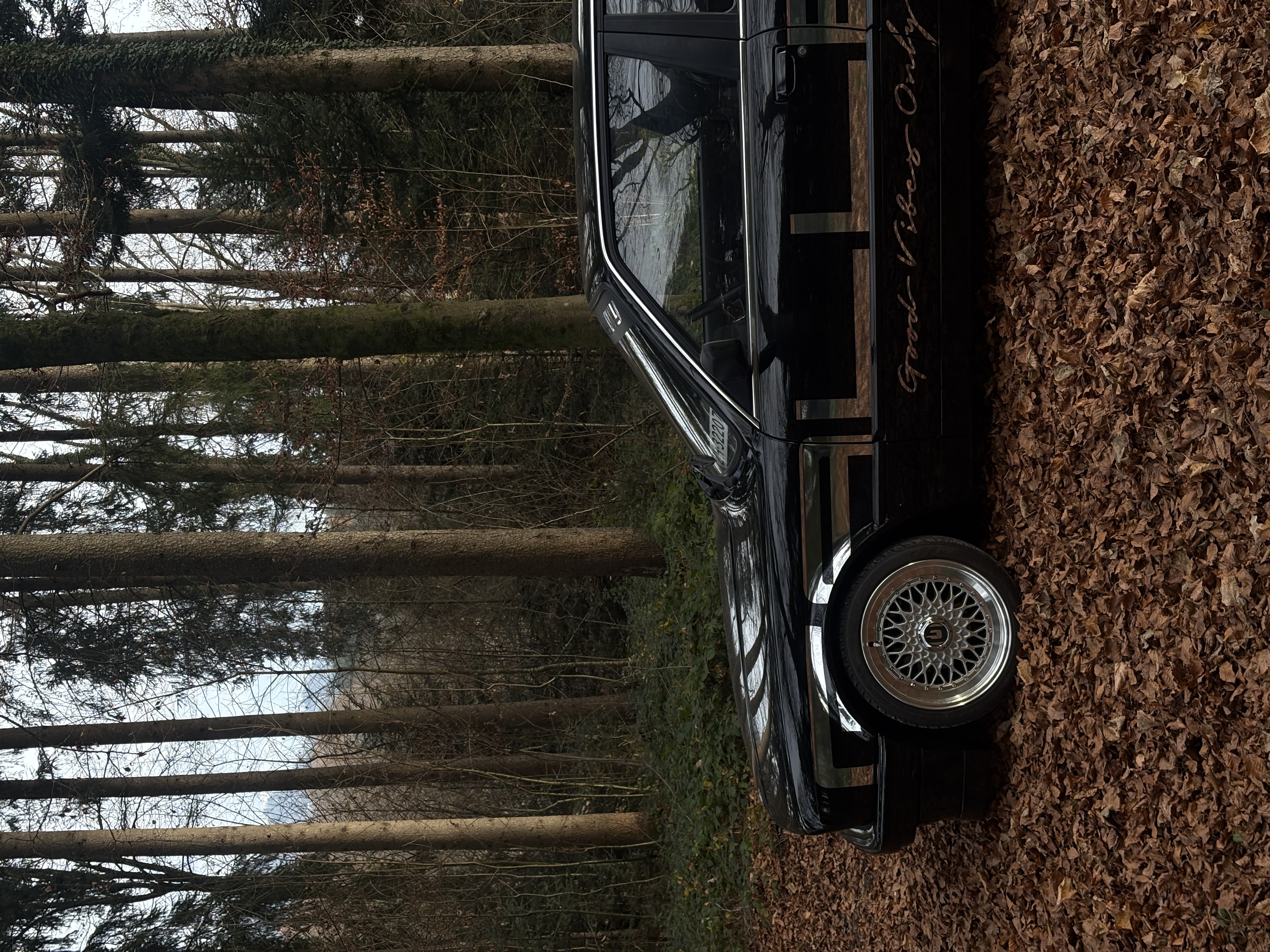 Schwarzer BMW E30 im Wald