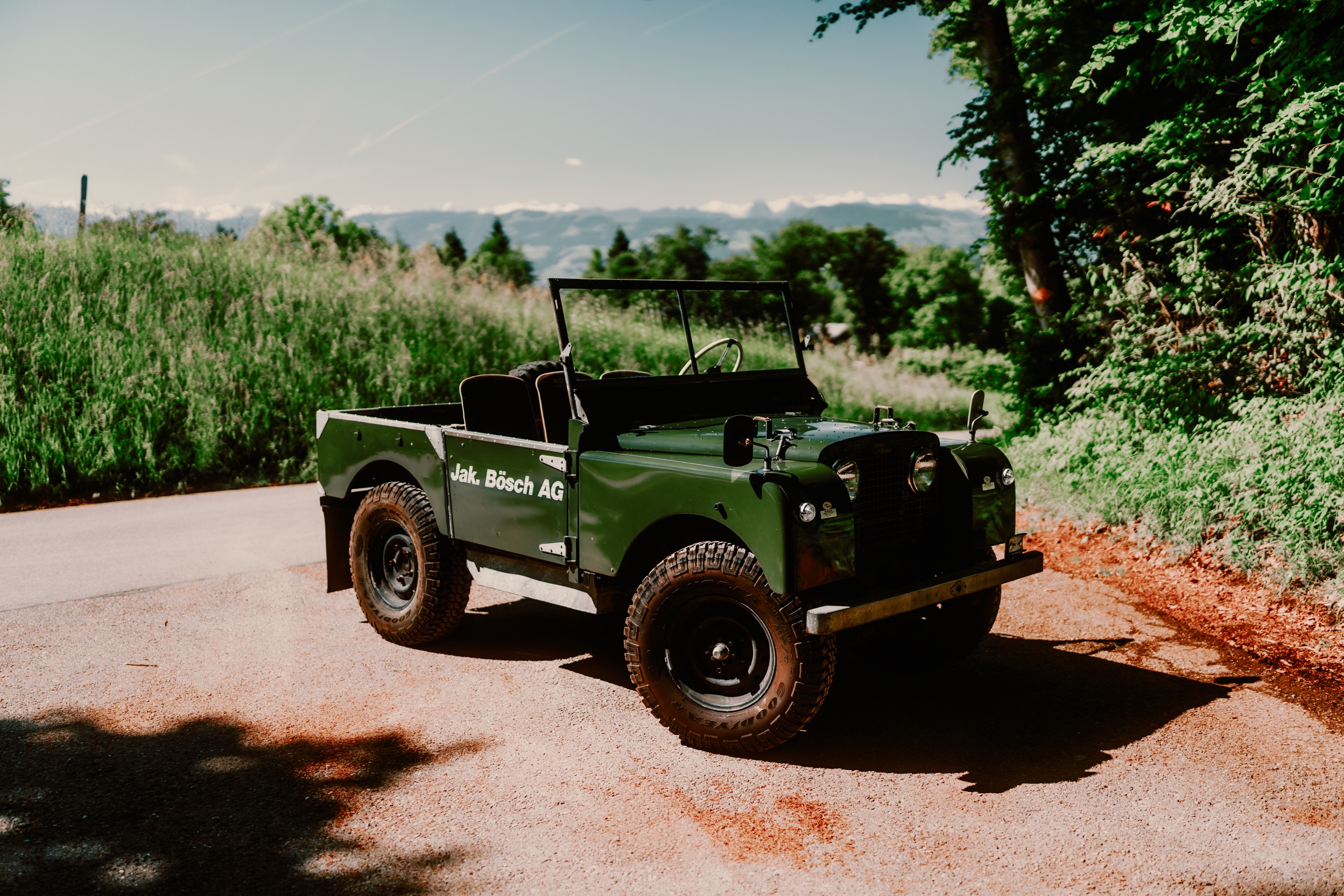 Grüner Land Rover Serie 1 auf einer Waldstrasse